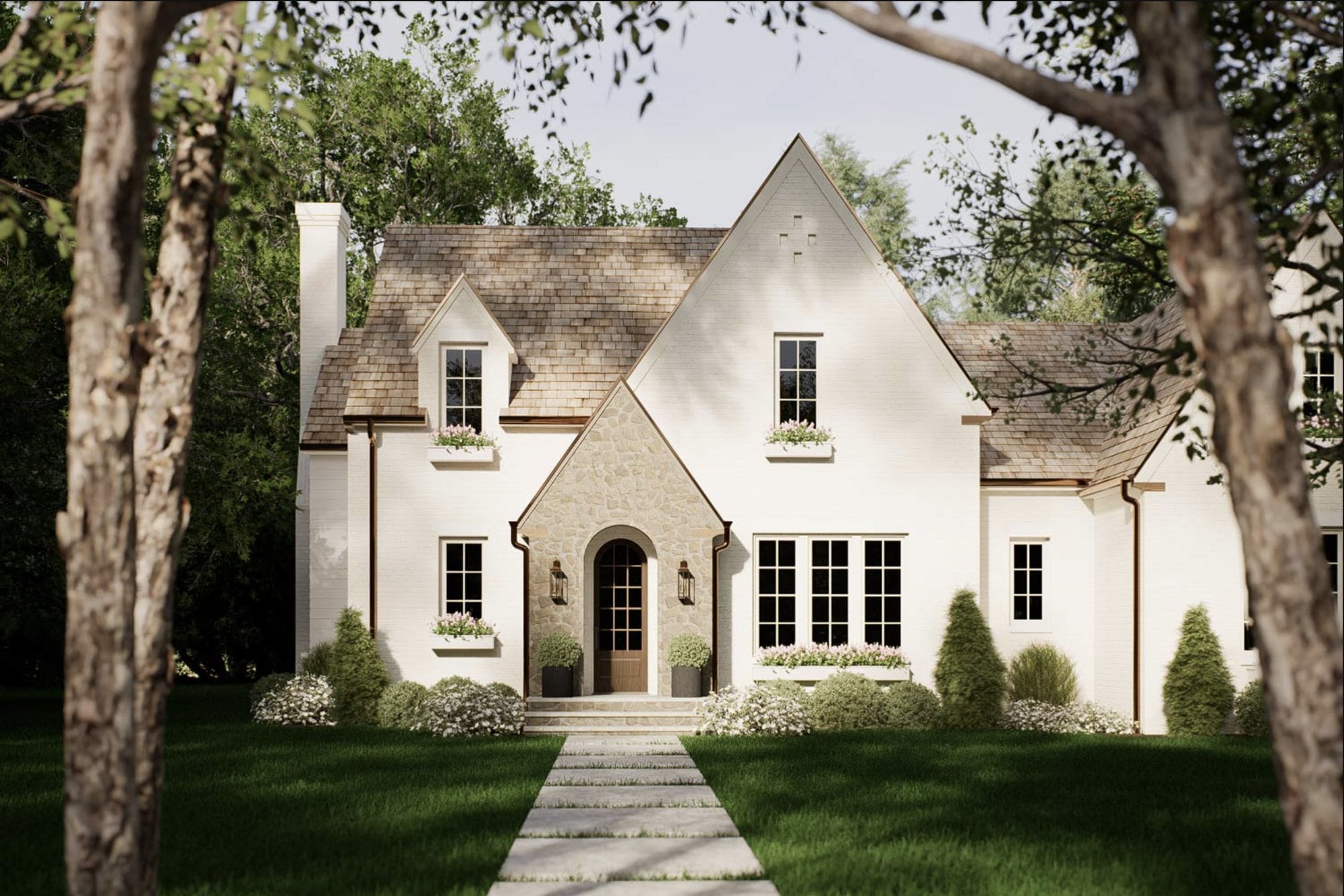 Front elevation of Meadowbrook Cottage — a white cottage with a stone entry, arched door and cedar-shake roof